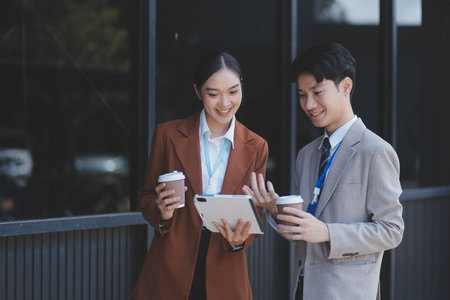 Successful young business people talking, working together in front of modern business buildingの写真素材