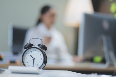 Young adorable Asian businesswoman working with work document during the night, working overtime at...