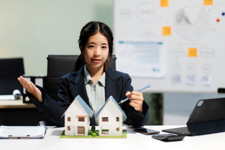 Real estate agents explain models of housing estates in projects to elaborate to clients, explaining and presenting information about homes and purchasing loans. Real estate trading concept.の写真素材