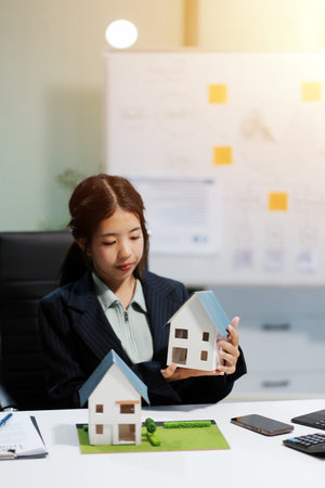 Real estate agents explain models of housing estates in projects to elaborate to clients, explaining and presenting information about homes and purchasing loans. Real estate trading concept.の写真素材