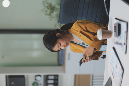 Asian Businesswoman Using laptop computer and working at office with calculator document on desk, doing planning analyzing the financial report, business plan investment, finance analysis concept.の写真素材