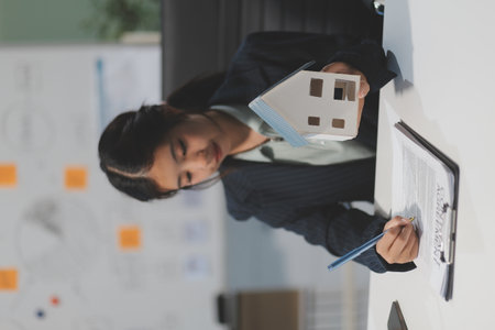 Real estate agents explain models of housing estates in projects to elaborate to clients, explaining and presenting information about homes and purchasing loans. Real estate trading concept.の写真素材