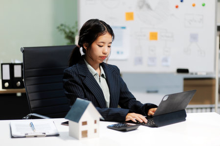 Real estate agents explain models of housing estates in projects to elaborate to clients, explaining and presenting information about homes and purchasing loans. Real estate trading concept.の写真素材