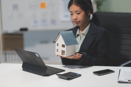 Real estate agents explain models of housing estates in projects to elaborate to clients, explaining and presenting information about homes and purchasing loans. Real estate trading concept.の写真素材