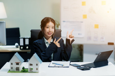 Real estate agents explain models of housing estates in projects to elaborate to clients, explaining and presenting information about homes and purchasing loans. Real estate trading concept.の写真素材
