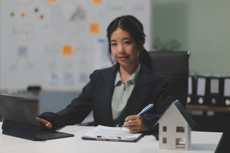 Real estate agents explain models of housing estates in projects to elaborate to clients, explaining and presenting information about homes and purchasing loans. Real estate trading concept.の写真素材