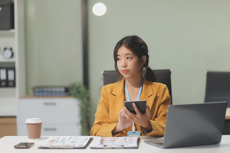 Young attractive businesswoman working on her project with laptop computer in modern office room.の写真素材