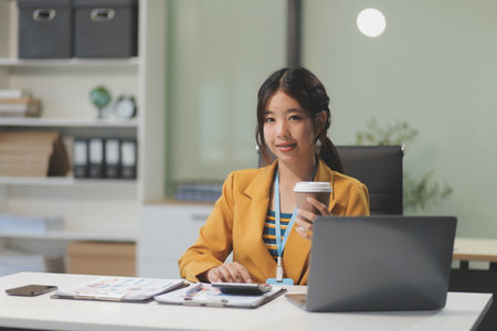 Young attractive businesswoman working on her project with laptop computer in modern office room.