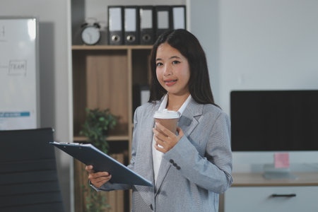 Asian Businesswoman working at office with document on desk, doing planning analyzing the financial report, business plan investment, finance analysis concept.の写真素材