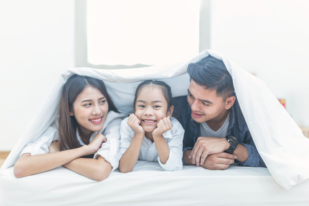 A happy asia family with kids in the living, Happy family mother, Father, Child daughter at home, Happy loving family, Father and his daughter child girl playing togetherの写真素材