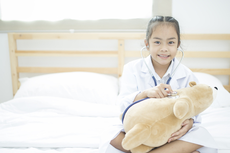 Little doctor, Cute little asian girl dressed like a doctor at homeの写真素材
