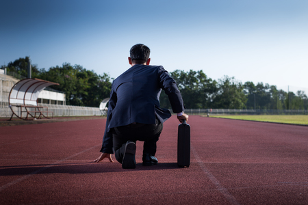 A businessman on a track ready for race in businessの写真素材