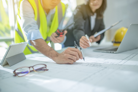 Engineer asia man and woman discussing about building plan for construction at job site, Selective focusの写真素材