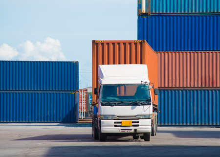 Forklift truck lifting cargo container in shipping yard or dock yard against sunrise sky for transportation importの写真素材