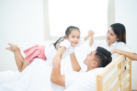 A happy asia family with kids in the living, Happy family mother, Father, Child daughter at home, Happy loving family, Father and his daughter child girl playing togetherの写真素材