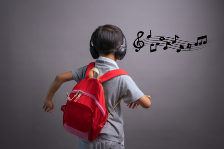 Cute funny children in dance studio, Cute little boy in headphones listening to music on color backgroundの写真素材