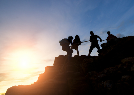 Asia couple hiking help each other silhouette in mountains with sunlight, Couple hiking help each other silhouette in mountains with sunlightの写真素材