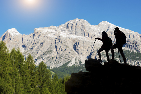 Hiker with backpacks reaches the summit of mountain peak. Success, freedom and happiness, Achievement in mountains. Active sport concept.の写真素材