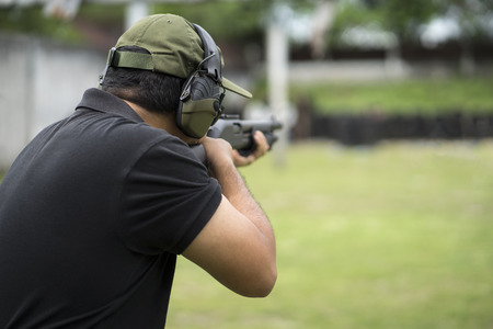 Man shooting on an outdoor shooting range, selective focusの写真素材