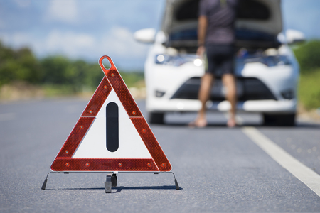 Red emergency stop sign and white car after accident on the roadの写真素材