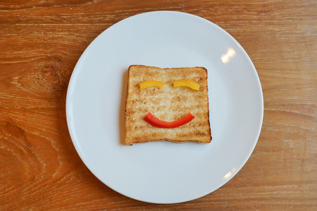 The smiling faces painted on the slice bread, Happy breakfast Conceptの写真素材