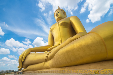 buddha image. Big golden buddha statue sitting on blue sky backgroundの写真素材