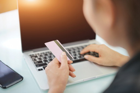 Young woman holding credit card and using laptop computer. Online shopping conceptの写真素材