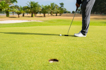 Golfer putting golf ball on the green golf.