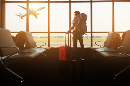 Passenger seat in departure lounge for see airplane, View from airport terminal. Sun light in vintage color selective focus, Transport and travel conceptの写真素材
