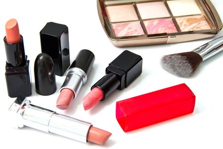 Makeup blush and lipsticks on white background