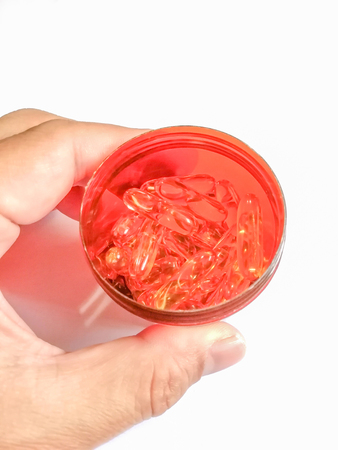 Fishoil capsule in Jar on hand on white backgroundの写真素材