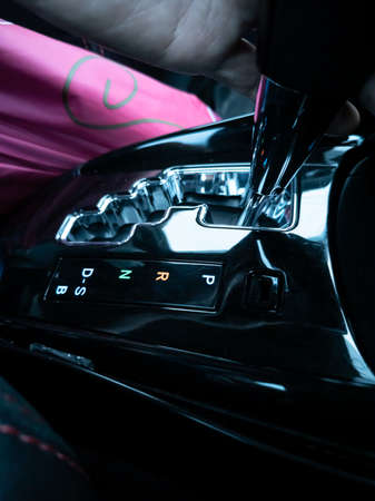Close-up (Bird's Eye View). Hands (partially visible), gear P (black and silver) to park. Bangkok, Thailand.の写真素材