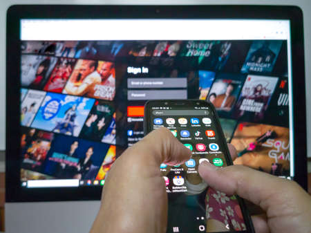 Asian hands use mobile phone to monitor or TV. Service providers of movies, music, games, shopping, food, beverages, etc., convenience in the present and future.の写真素材