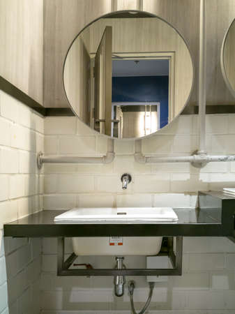 White washbasin, and circular mirror, old style, retro design, ready to show drain (painted white)の写真素材