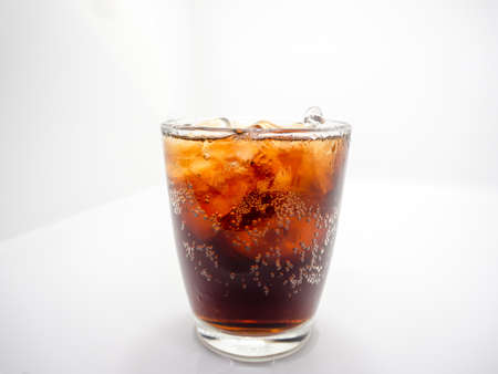 Close-up and isolated in the middle, soft drink and ice in clear curved glass, white backgroundの写真素材