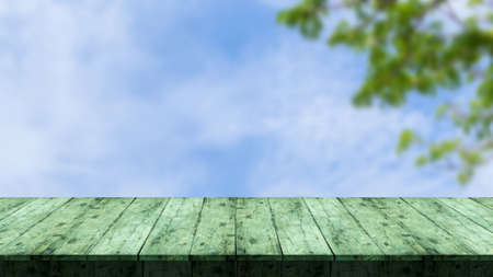 Wooden table is in front, and the image is blurred, of the background of the branches and the sky....
