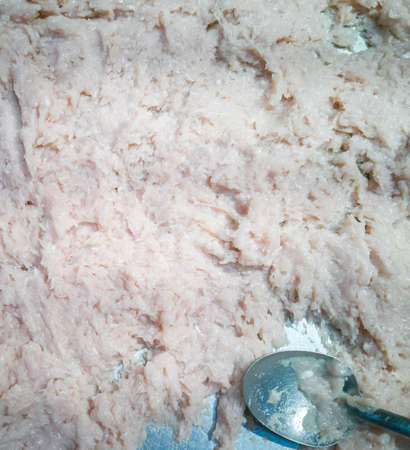 Close up of uncooked minced meat with a spoon on the table