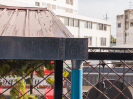 Eye level view of stainless steel guttering on corrugated roof and blurred background.