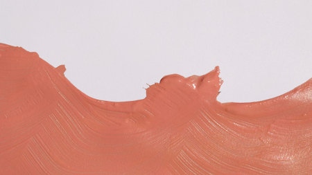 Pink acrylic paint stroke with thick brush texture on white paper. A soft aesthetic coral splash...