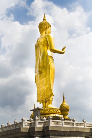 The respectable golden Buddha statue. Standing outdoors in the republic  park and beautiful sky.の写真素材