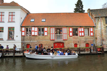 Bruges, Belgium, April 16, 2015. Tourists on a canal boat tourのeditorial素材