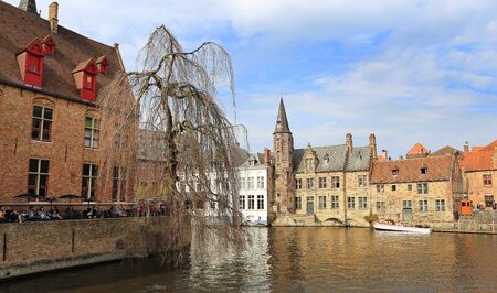 Bruges, Belgium, April 16, 2015. Tourists on a canal boat tourのeditorial素材