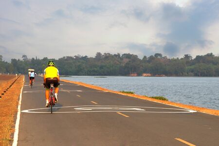 a man riding bicycle on sunset river viewの写真素材