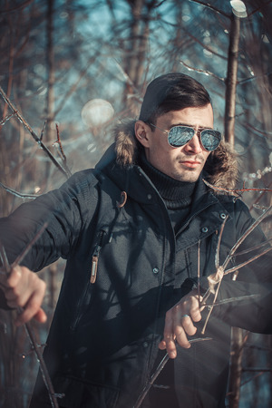 a handsome young man with spectacles in the Park in winterの写真素材