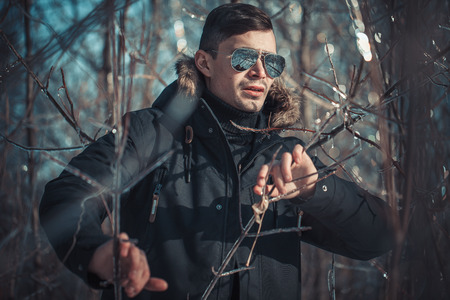 a handsome young man with spectacles in the Park in winterの写真素材