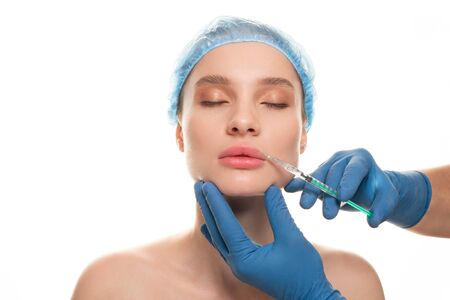 Young beautiful woman receiving a cosmetic botox injection in her face, close upの写真素材