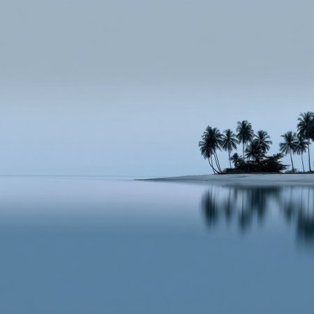 A tranquil tropical island scene at dawn, featuring silhouetted palm trees reflecting on calm ocean waters, enveloped in soft blue hues for a serene escape.の素材