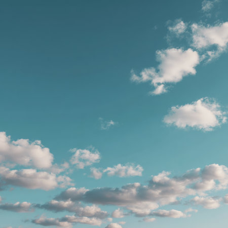 A beautiful blue sky adorned with soft, fluffy clouds, perfect for evoking a sense of peace and tranquility in artworks, promotions, or nature-themed projects.の素材