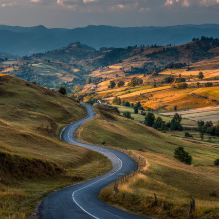 Beautiful winding road meanders through peaceful hills adorned with lush greenery and rolling fields, creating a perfect outdoor escape under a captivating sky at dusk.の素材