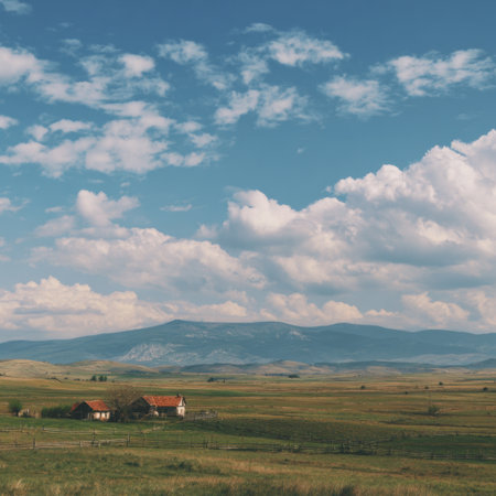 A stunning view of rolling hills under a bright blue sky filled with fluffy clouds, encapsulating the essence of rural beauty and natural tranquility in a serene environment.の素材